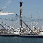 Fairing recovery ships, GO Ms Tree and GO Ms Chief, in front of Falcon 9 booster, with their nets deployed