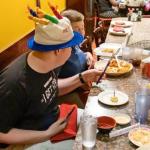 Sam honored with tiny cake with a birthday candle and set of chopsticks at Fuji Ya